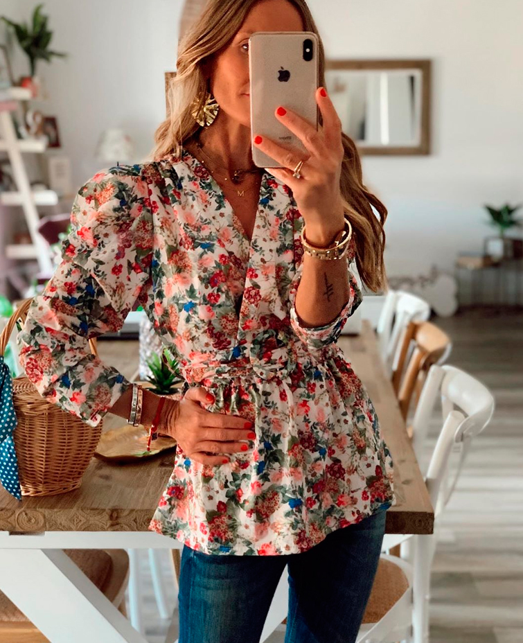 La influencer Maribel @mdfhima se hace un selfie en el que luce un look formado por vaqueros azules y una blusa floreada de corte peplum, lo que se considera una de las camisetas disimular barriga
