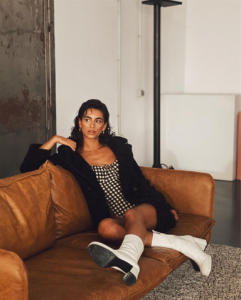 La acrtiz Begoña Vargas es una de las influencers Instagram España revelación 2022 y posa sentaba en un sofá marrón